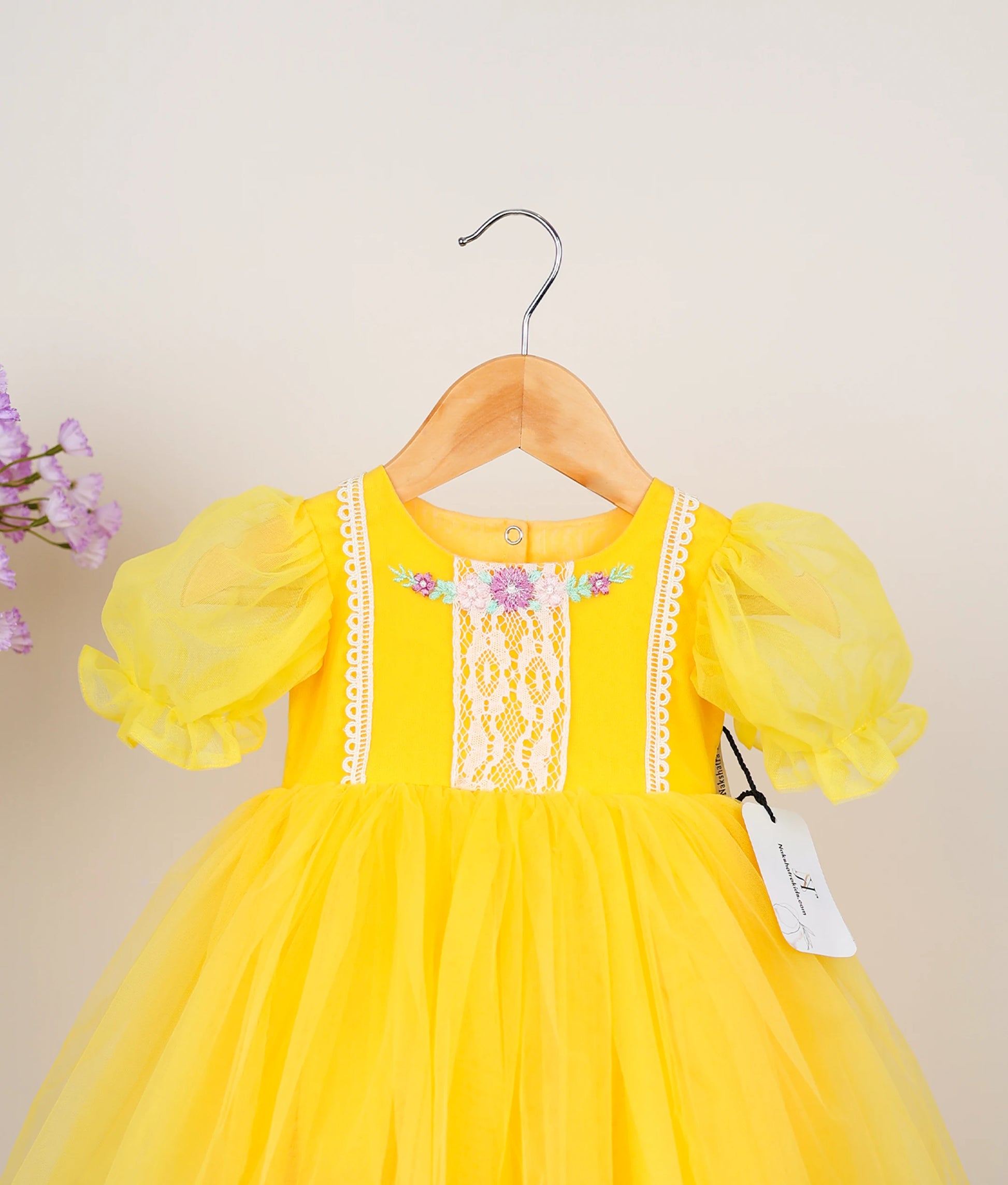 Close view of yellow embroidery casual frock against plain background