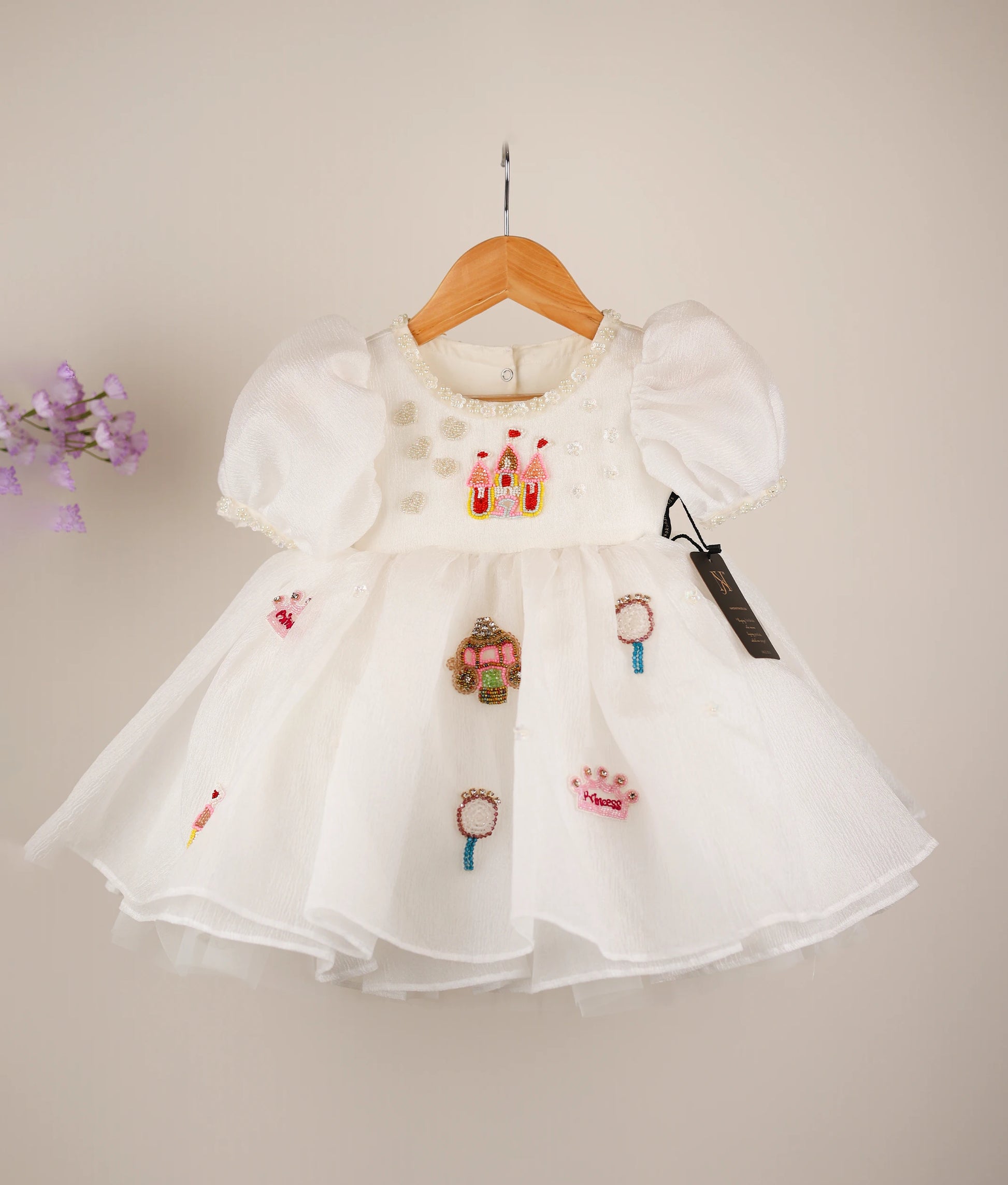 Front view of an off-white princess-themed dress against white background