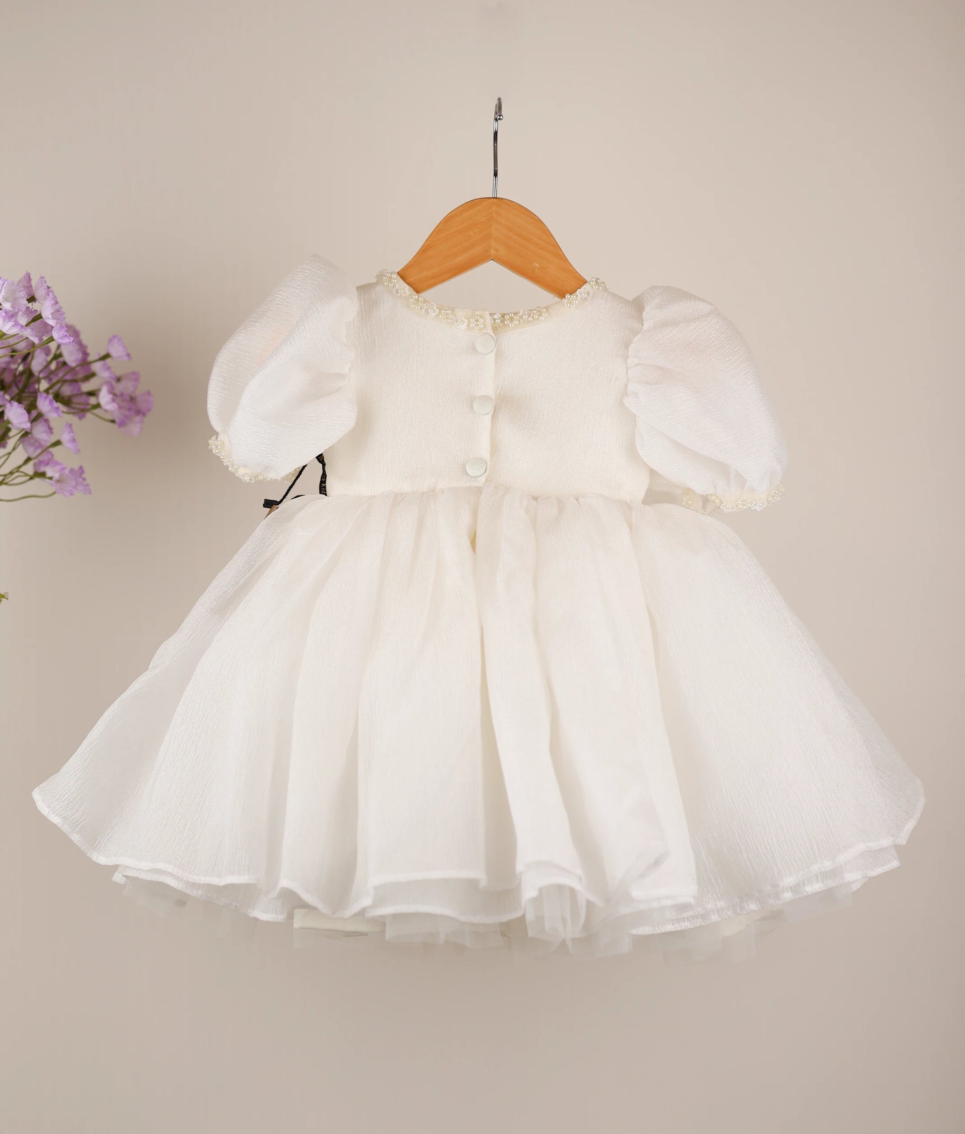 Back view of an off-white princess-themed dress against white background