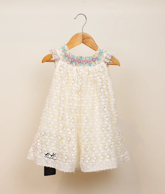 Front view of crochet floral handworked baptism frock against plain background 