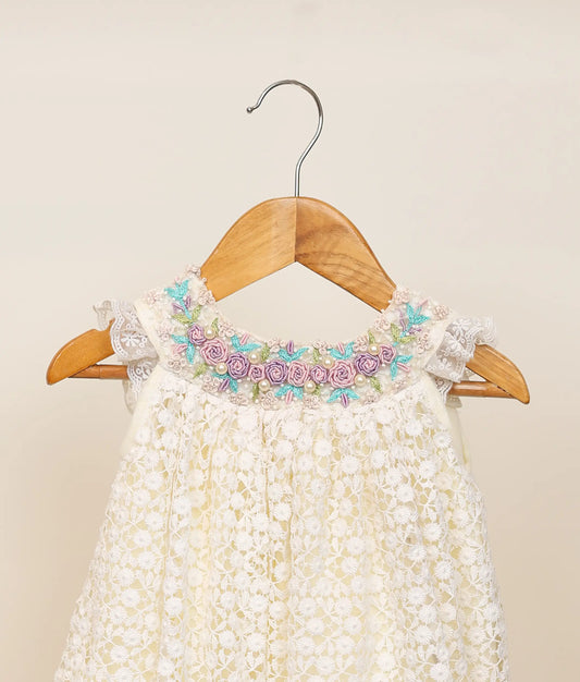 Close view of an crochet floral handworked baptism frock against plain background 