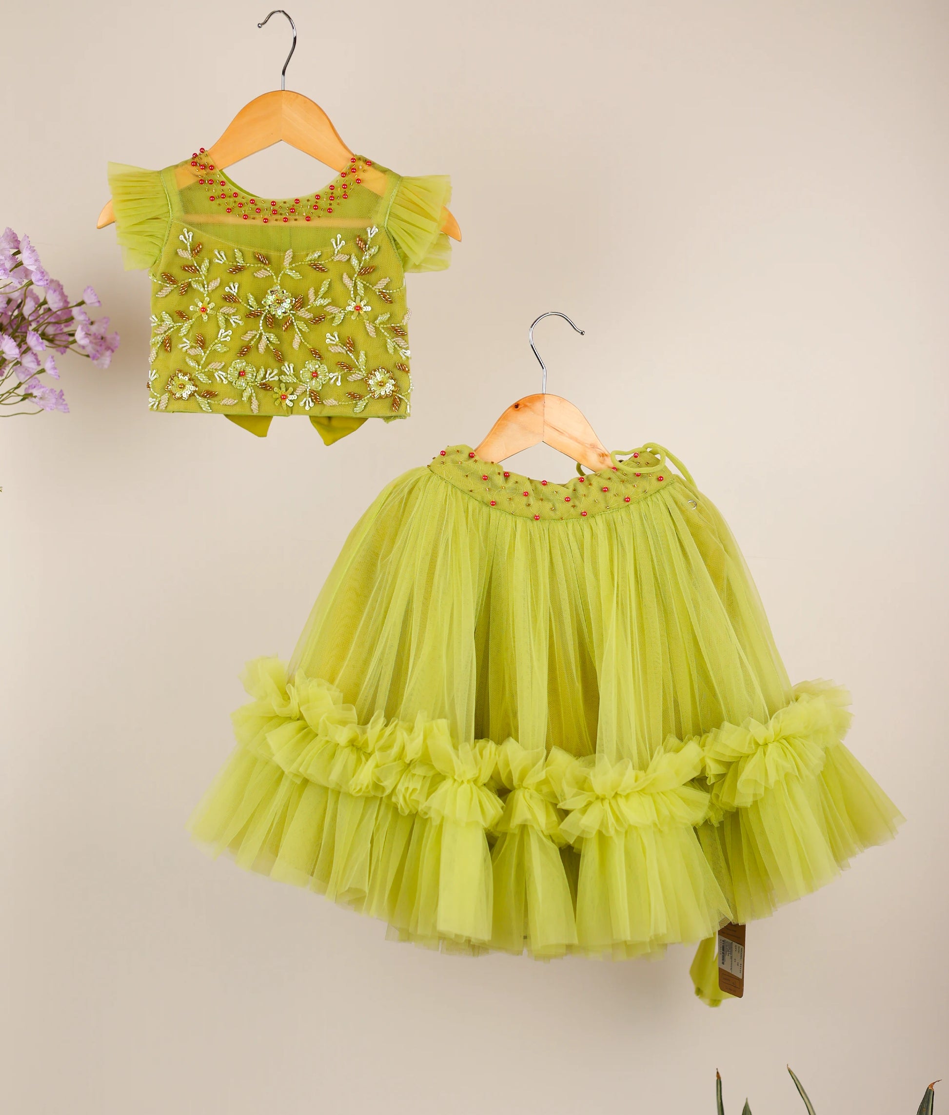 Pastel green handworked skirt top against beige background