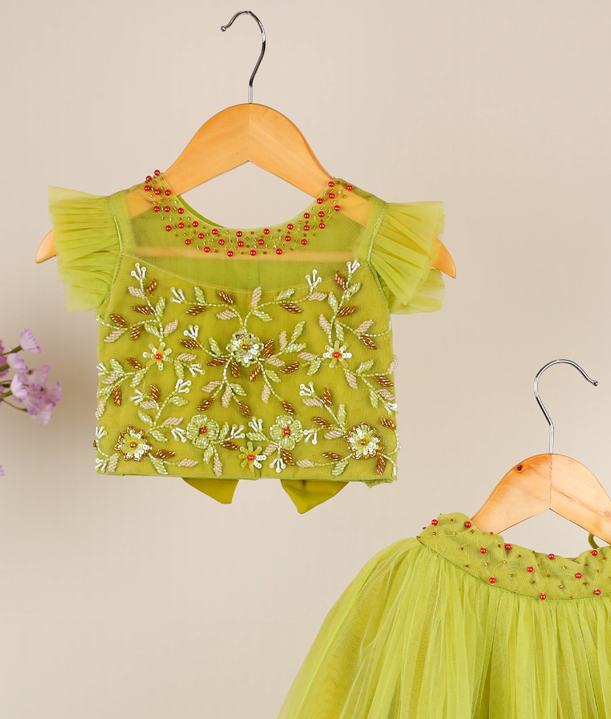 Pastel green handworked skirt top against beige background