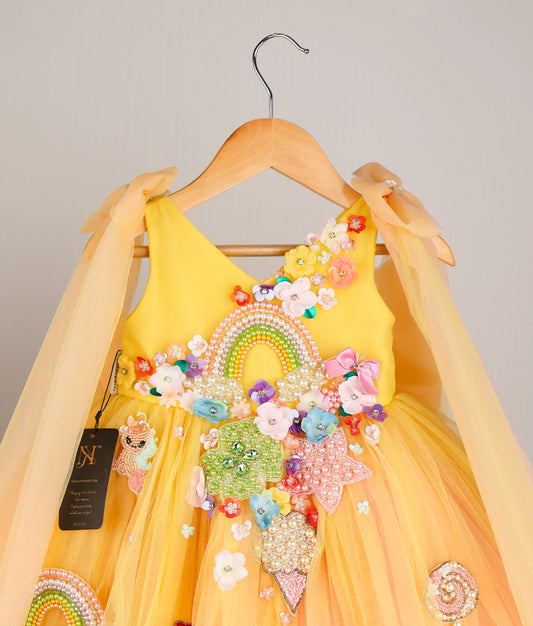 Close view of yellow tulle net Handworked Multi-Theme Birthday Frock against plain background