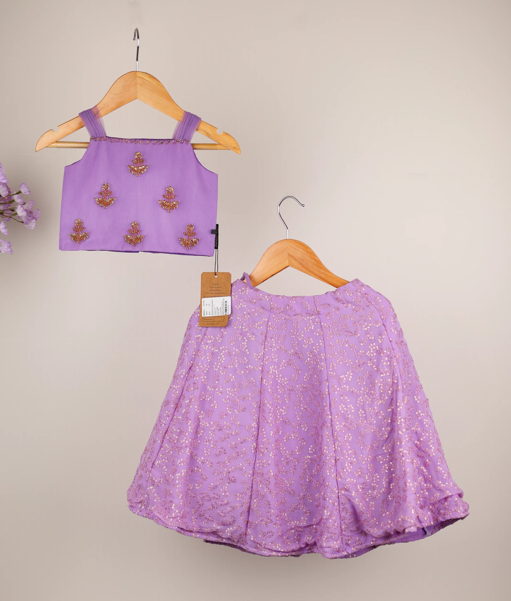Lavender handworked top and georgette skirt against plain background  