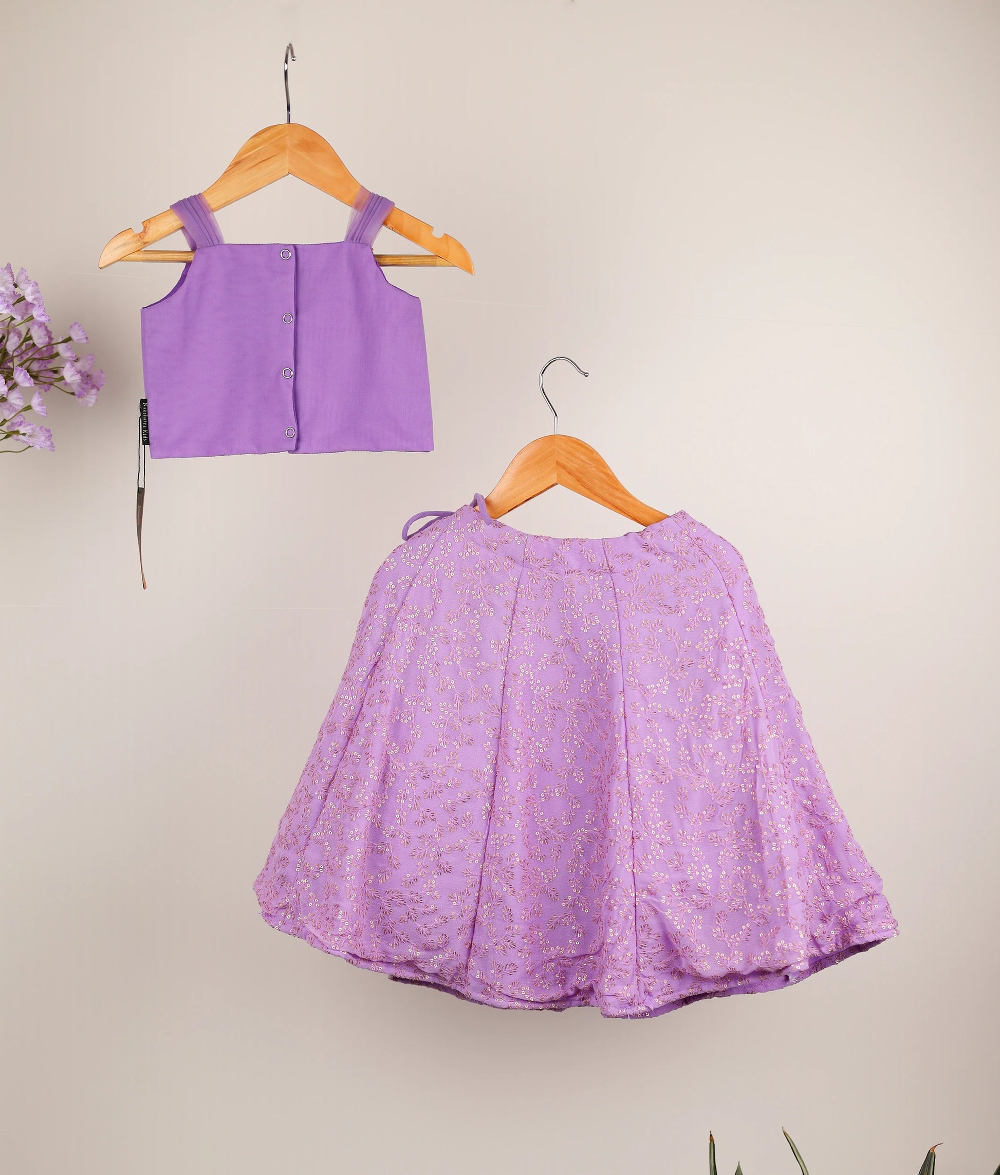 Back view of a lavender handworked top and georgette skirt against a plain background.
