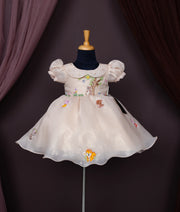 Beige baby girl dress with puff sleeves, Peter Pan collar, and cartoon forest animal embroidery.