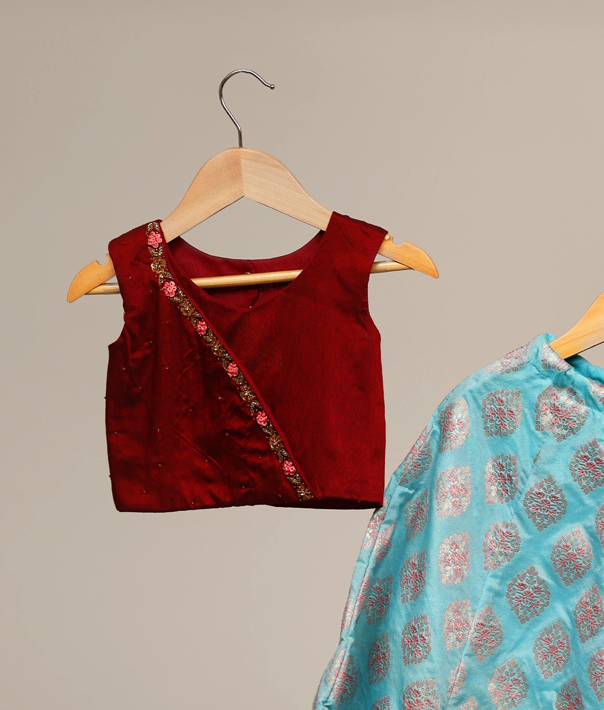 Close view of a maroon handworked top with banarasi peacock blue skirt 