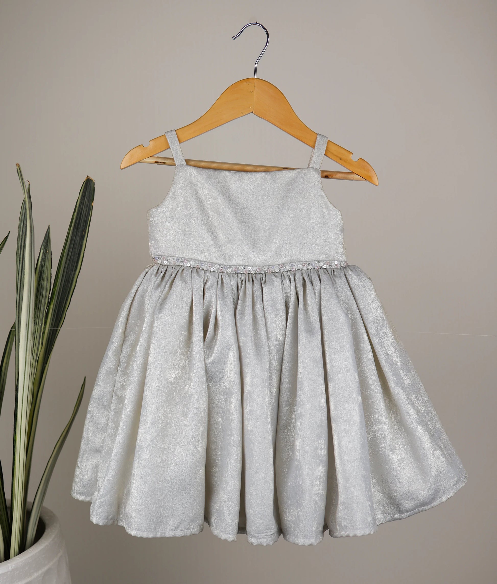 Front view of an milan foil handworked birthday frock against plain background