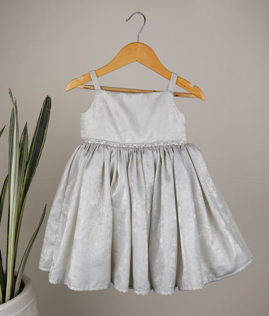 Front view of an milan foil handworked birthday frock against plain background