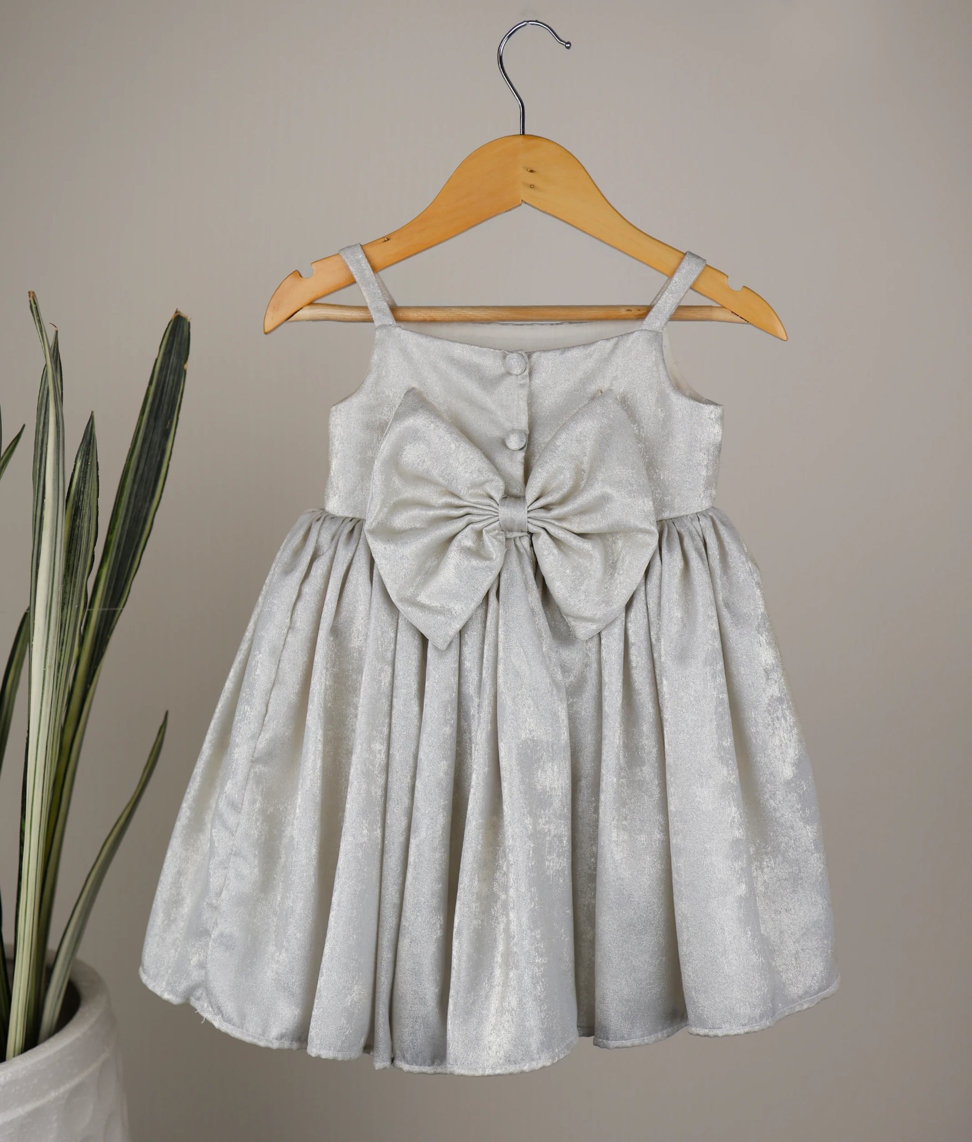 Back view of an milan foil handworked birthday frock against plain background