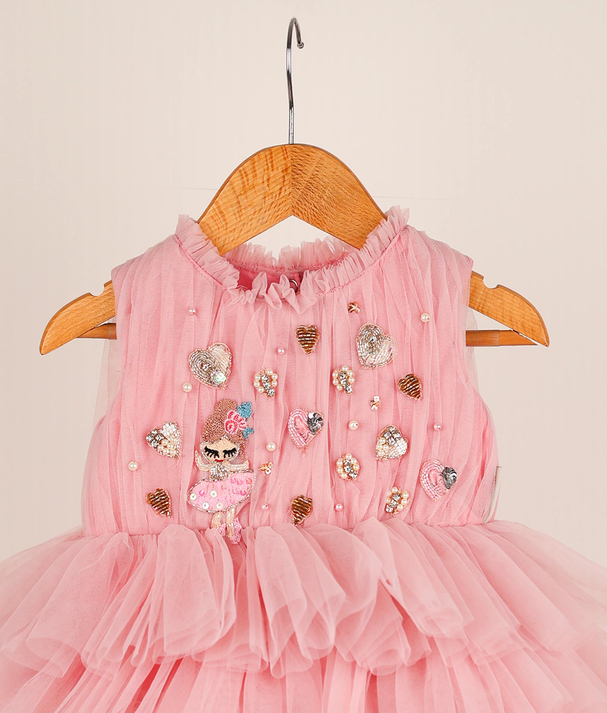 Close view of pink fairy-themed step birthday dress against plain background