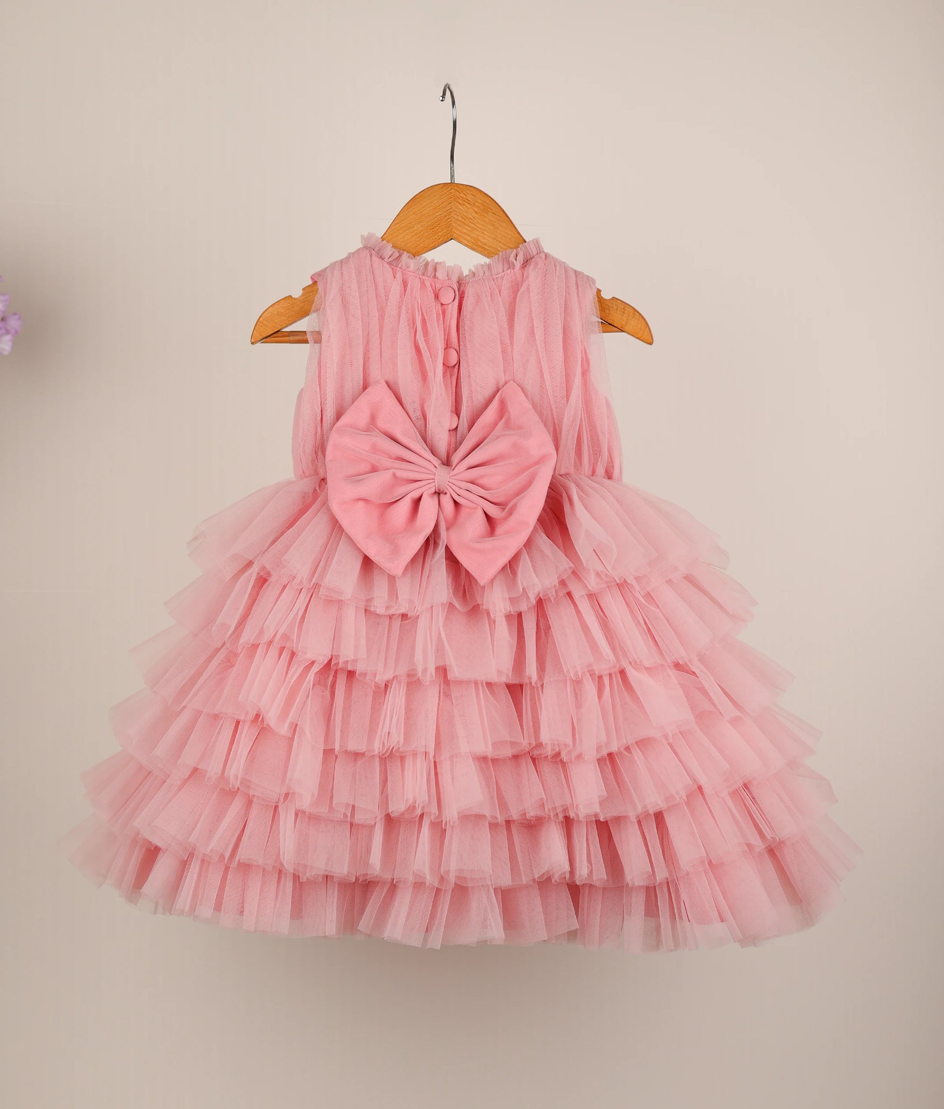 Close view of pink fairy-themed step birthday dress against plain background