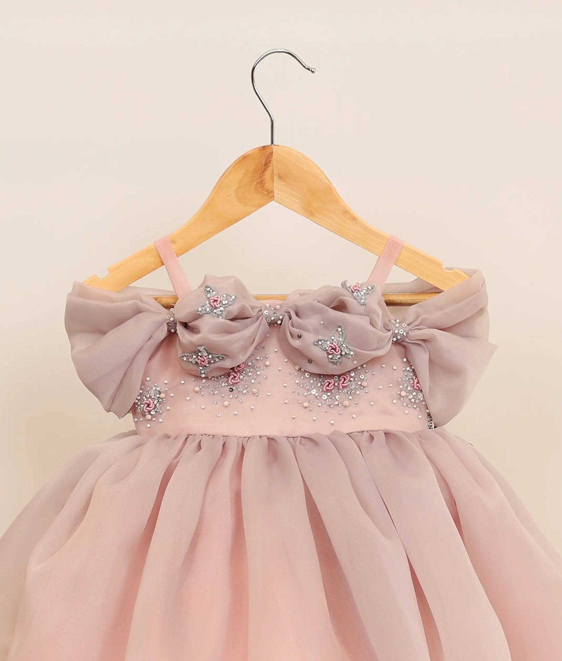 Close view of plain organza handworked birthday gown against plain background