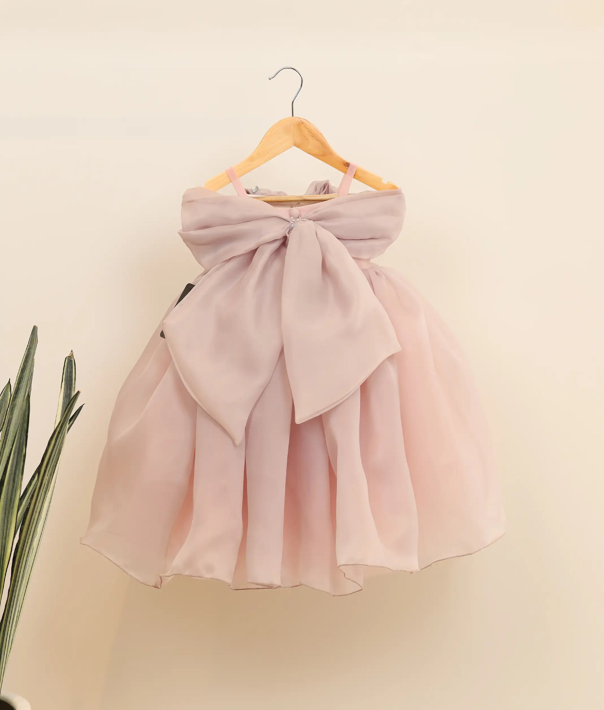 Back view of plain organza handworked birthday gown against plain background