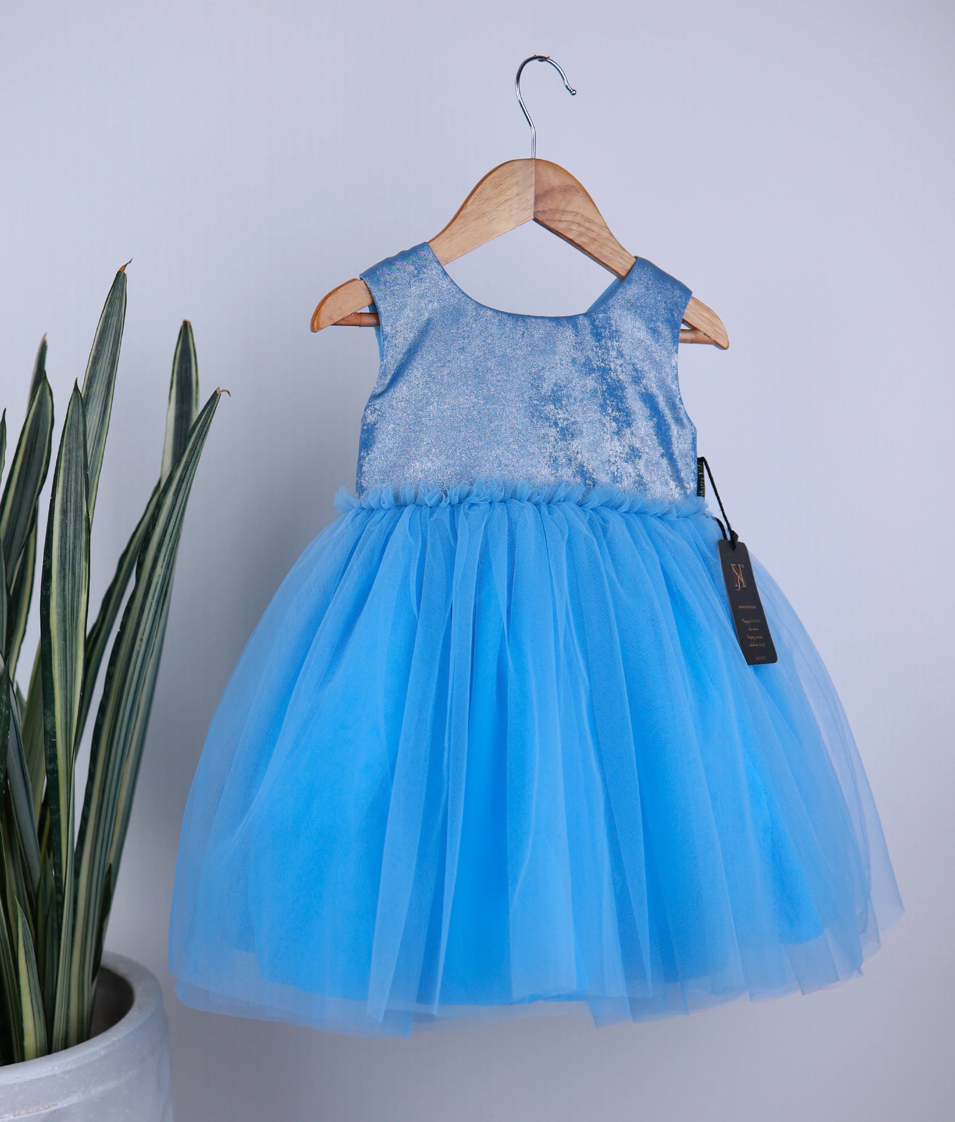 Front view of an pastel blue milan oil tulle net birthday frock against white background
