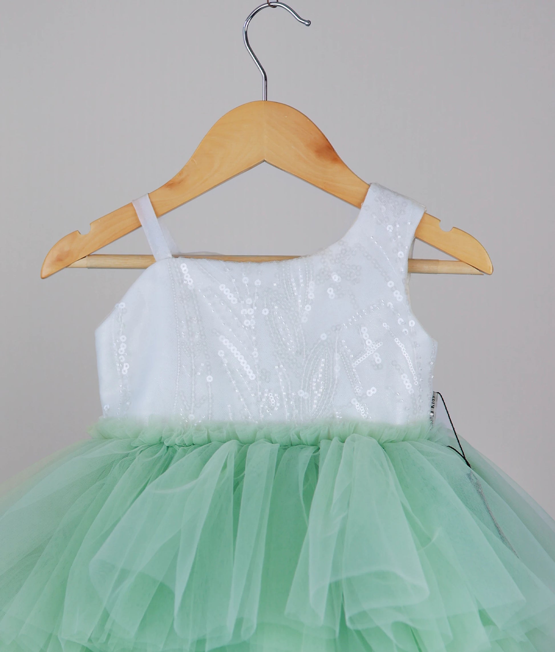 Close view of an off-white work material yoke with pastel green birthday frock with white background