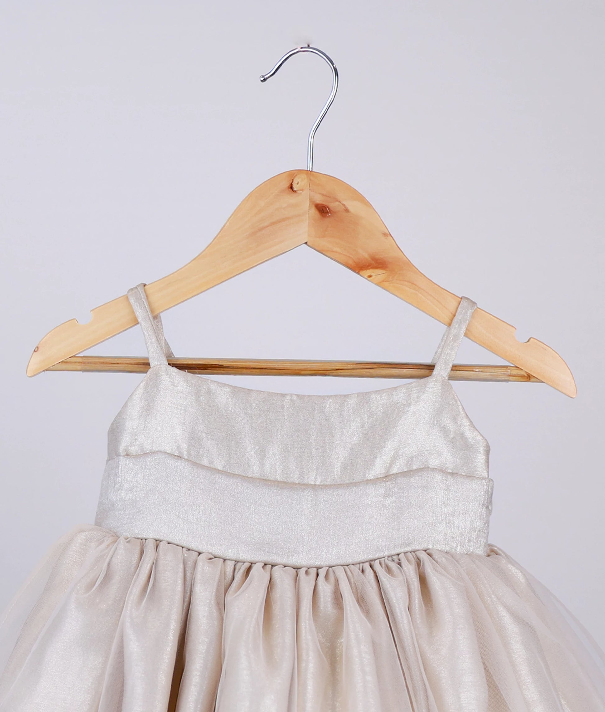 Close view of golden milan foil birthday frock for baby girl against white background
