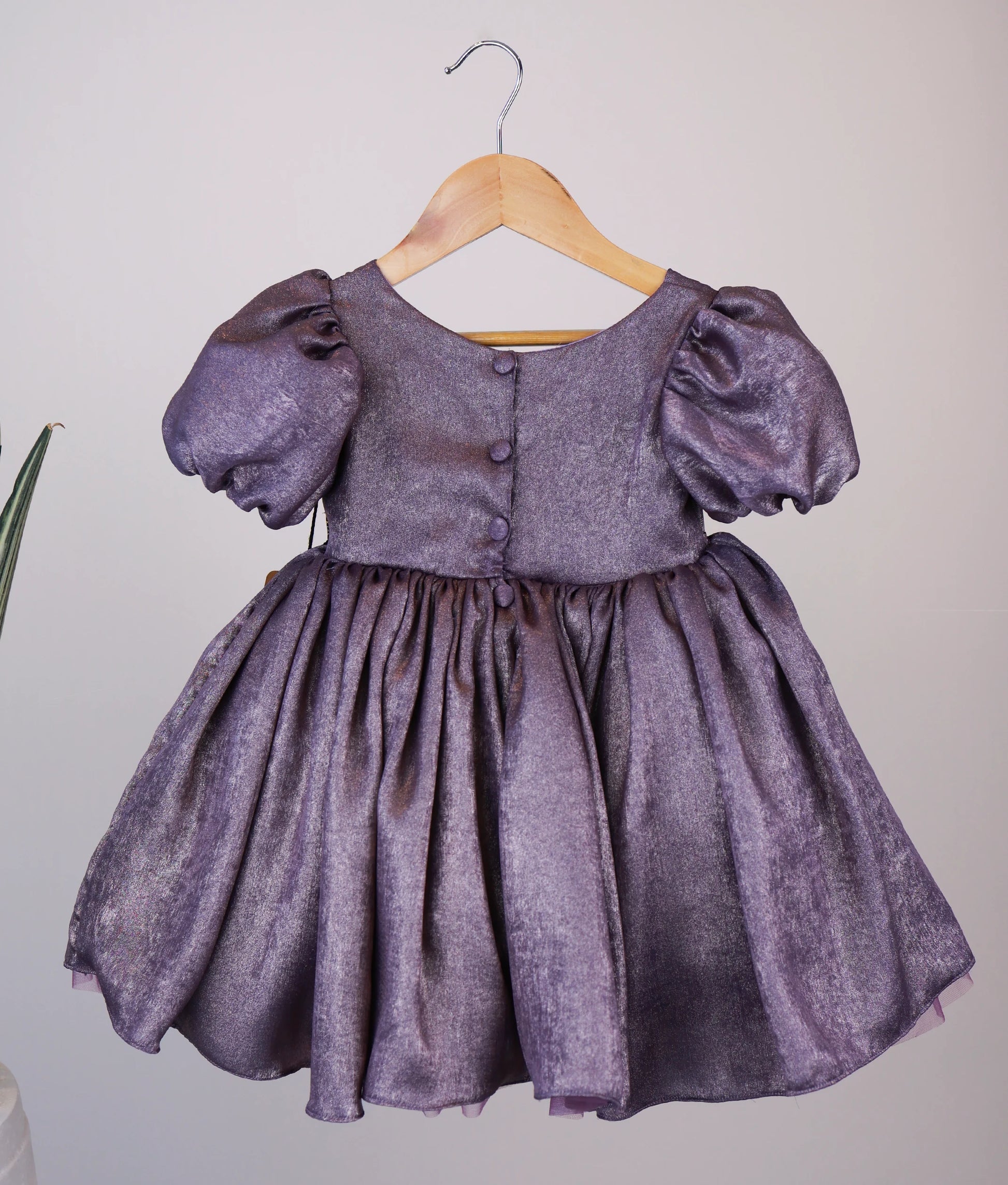 Back view of an handworked milan foil frock against white background