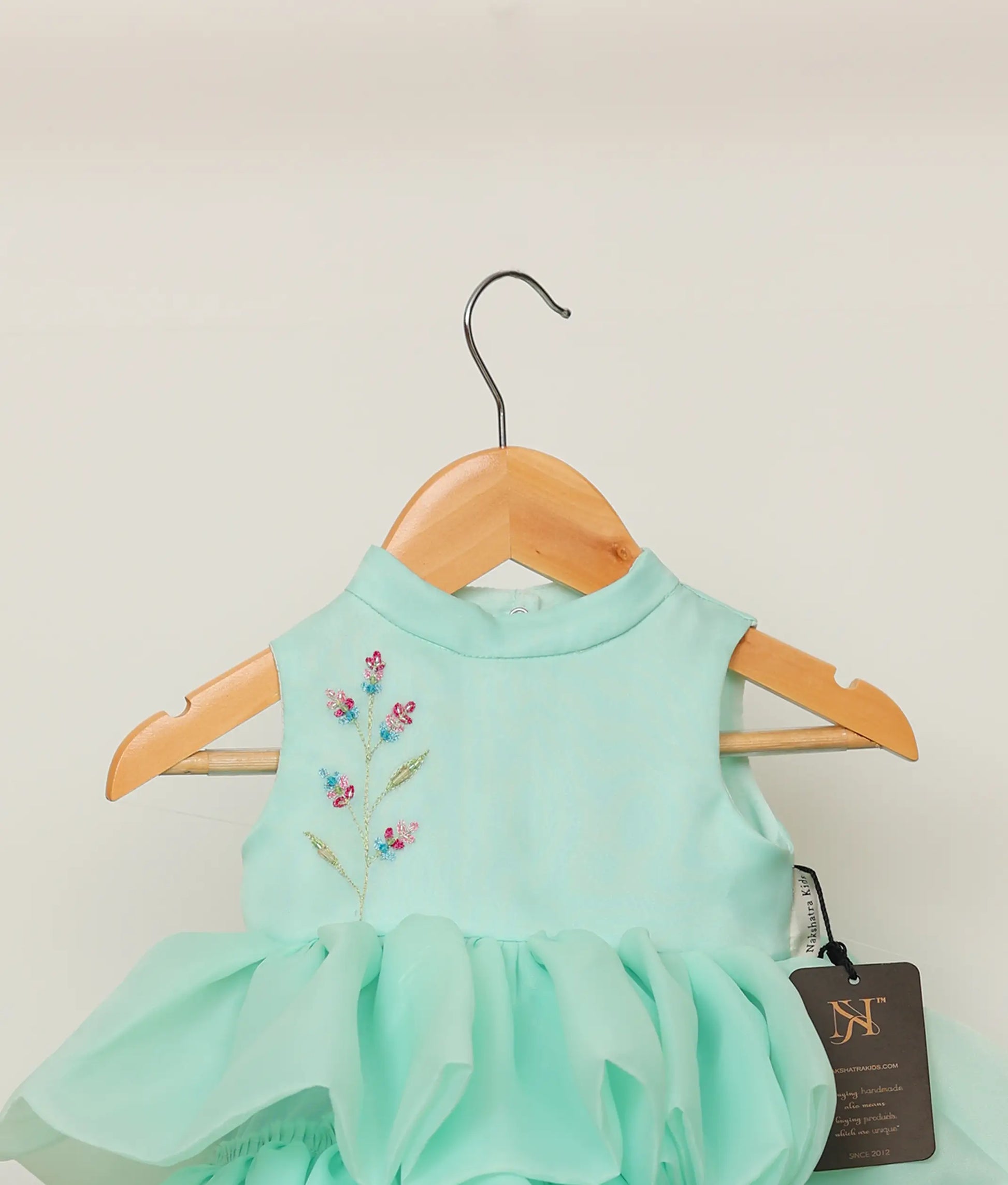 Close view of an plain organza floral handworked step birthday dress against plain background