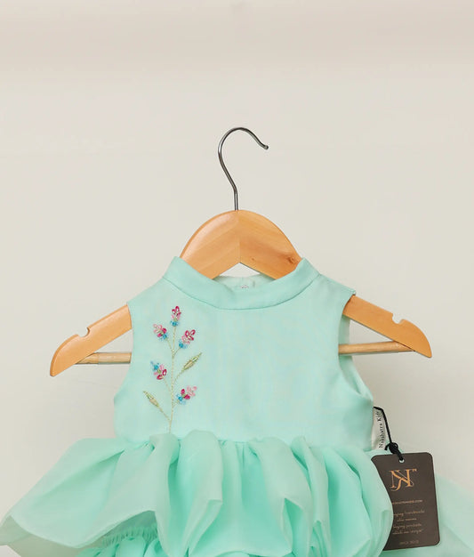 Close view of an plain organza floral handworked step birthday dress against plain background