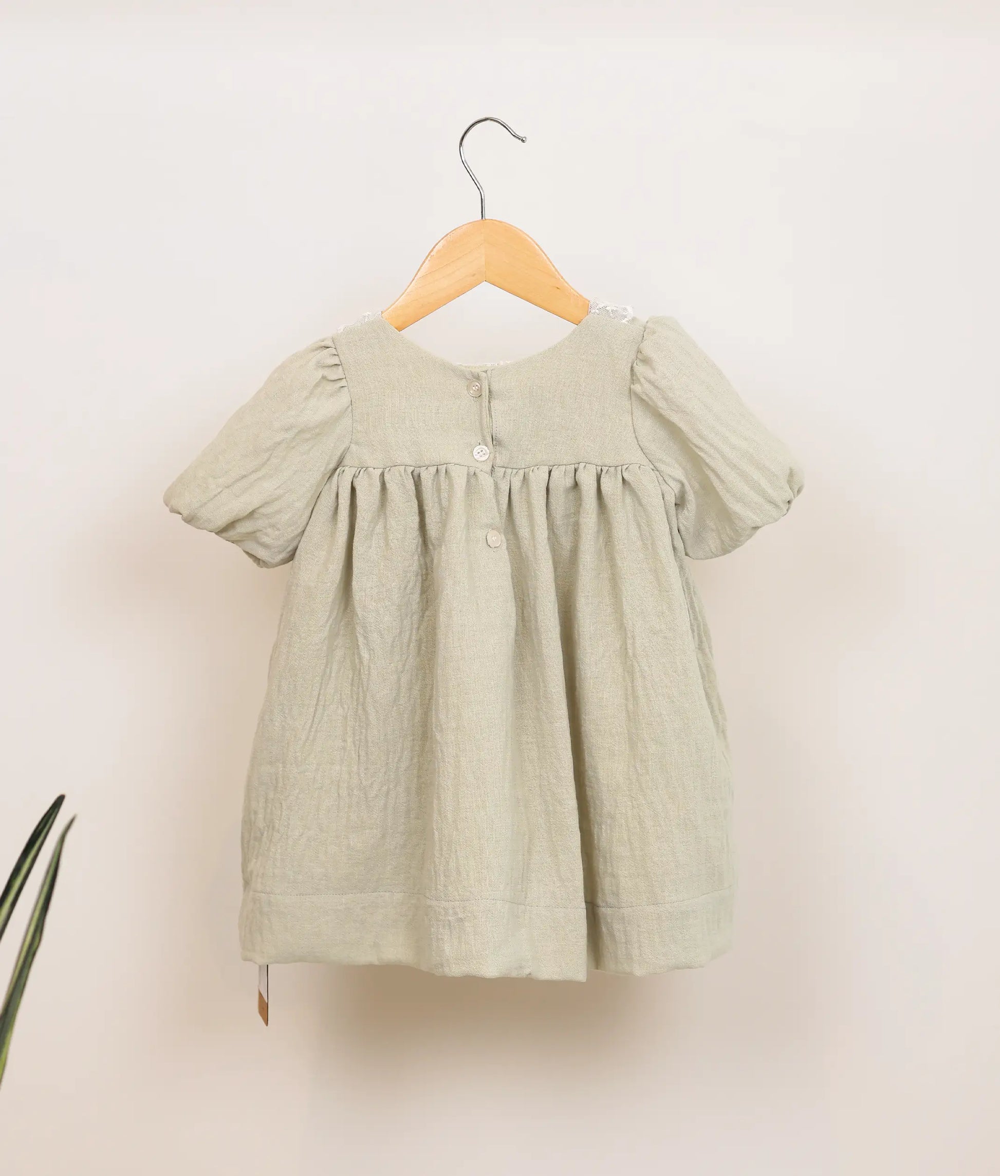 Back view of a pastel green linen christmas frock.