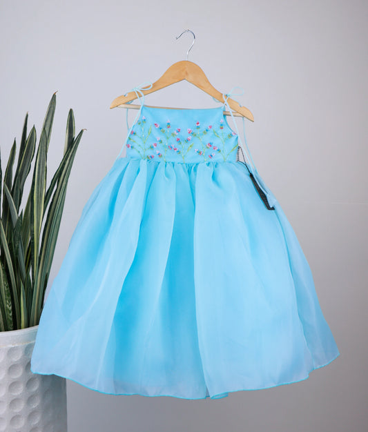 Front view of sky blue handworked birthday gown against white background