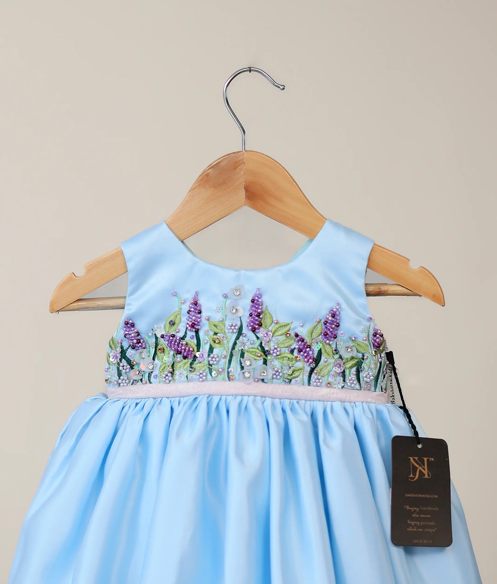 Close view of blue bridal satin organza flower-themed dress with white background