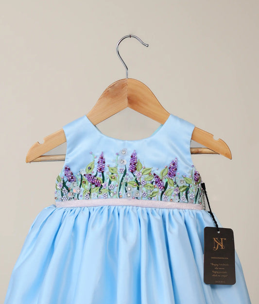 Close view of blue bridal satin organza flower-themed dress with white background