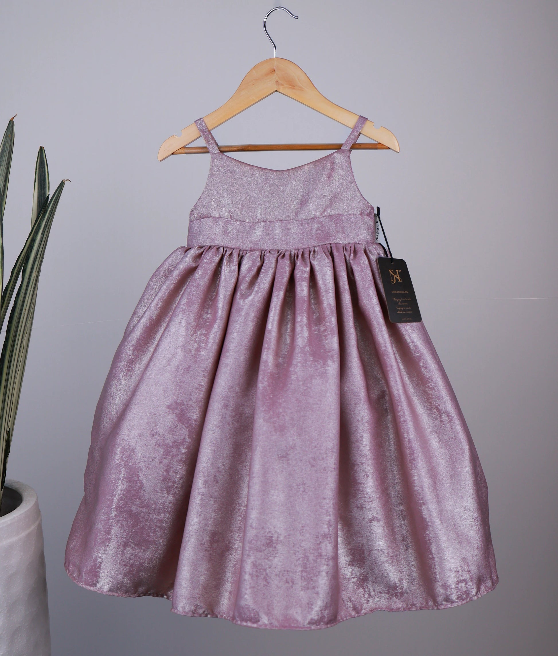 Onion pink gown on a hanger against a plain background.