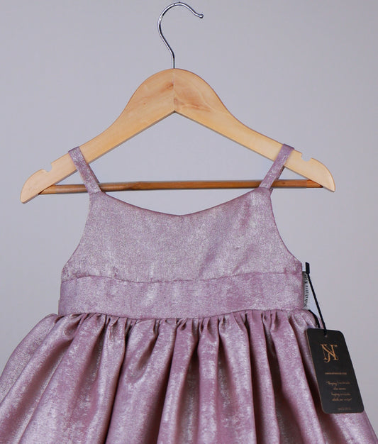 Close view of an onion pink gown on a hanger with a visible tag against a plain background.