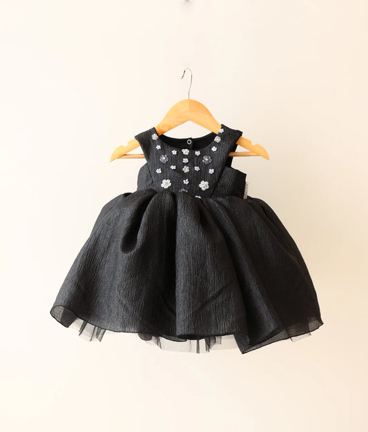 Front view of black crush organza floral handworked birthday frock against plain background