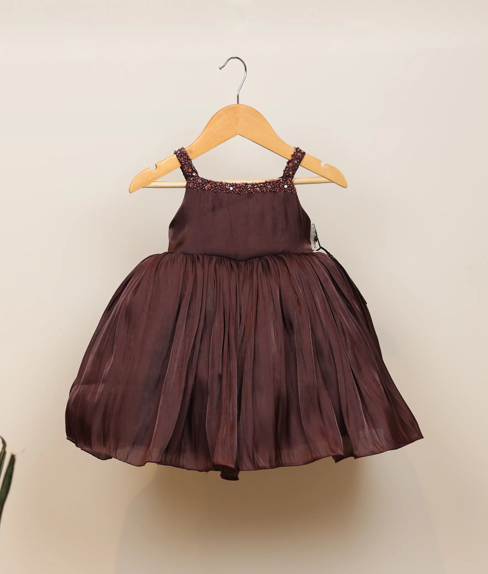 Front view of a coffee-brown lacer organza handworked birthday frock against plain background