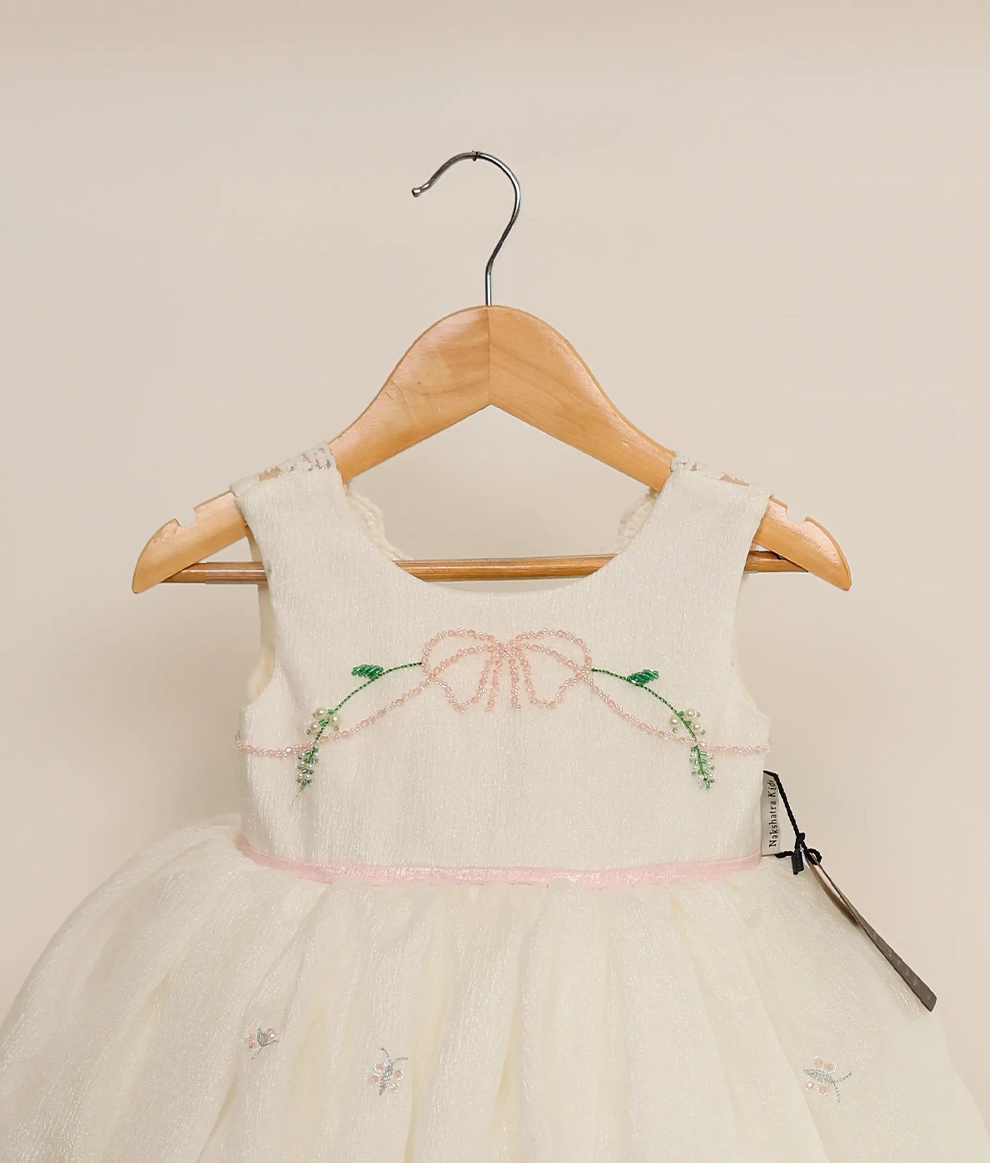 Close view of a crushed organza floral handwork birthday dress against plain background