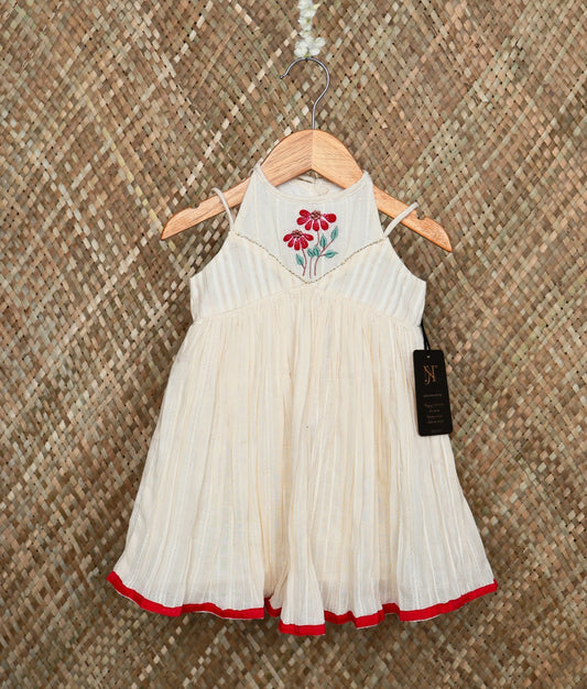 Traditional off-white baby girl dress with red floral embroidery and a red border, festive ethnic wear.