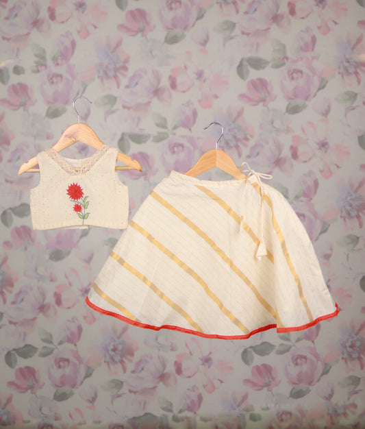 Off-white floral embroidery top and striped flared skirt with red hemline.