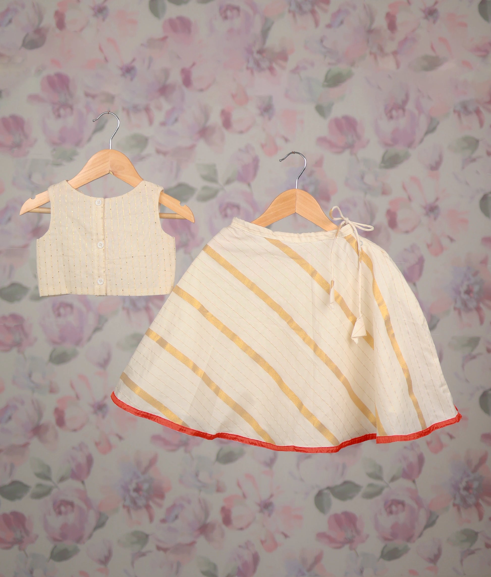 Back view of an off-white floral embroidery top and striped flared skirt with red hemline.