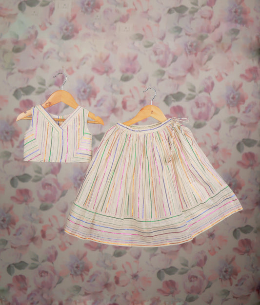 Ethnic dress with a multicolor striped short top and matching pleated skirt set.