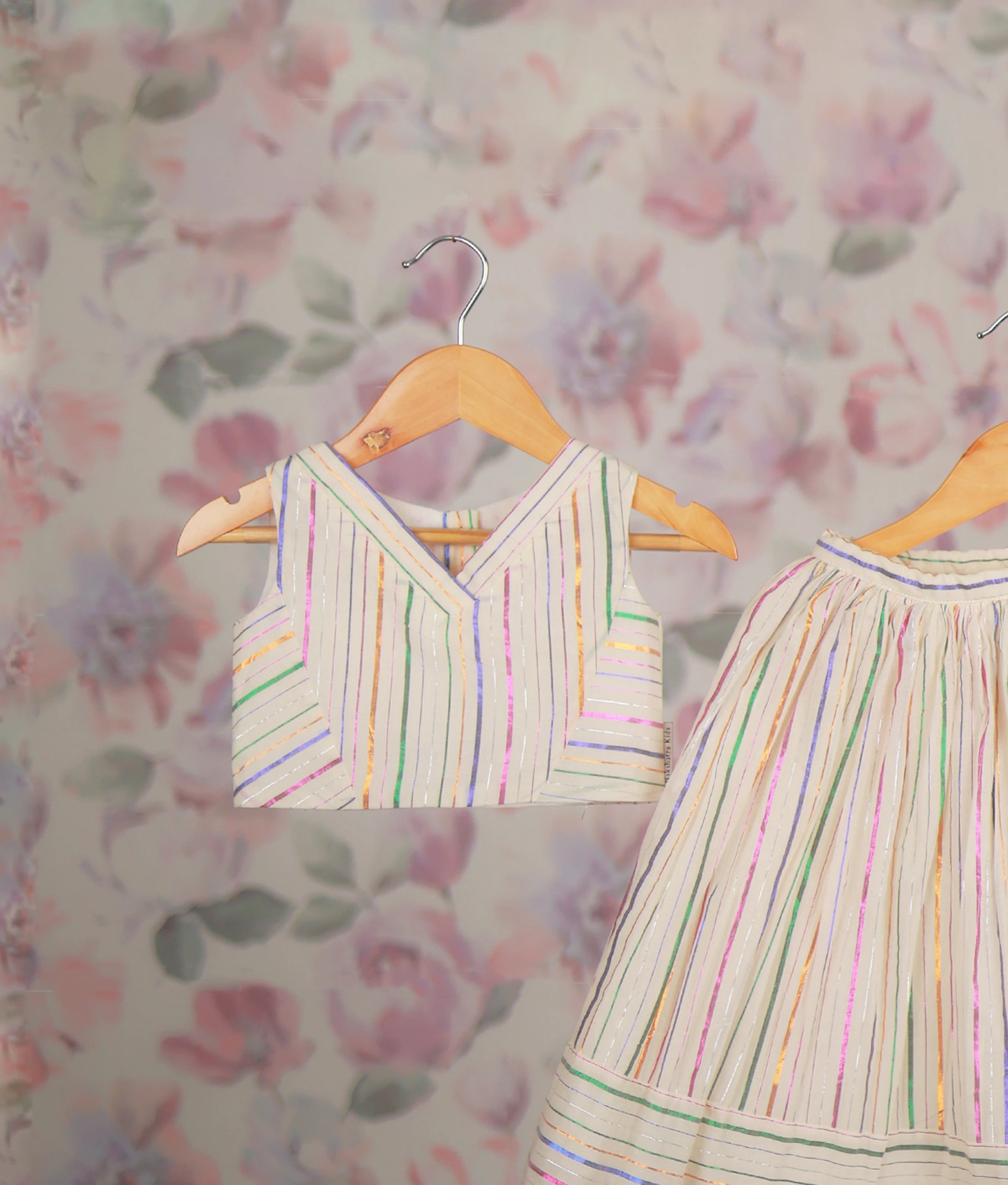 Close view of an ethnic dress with a multicolor striped short top and matching pleated skirt set.