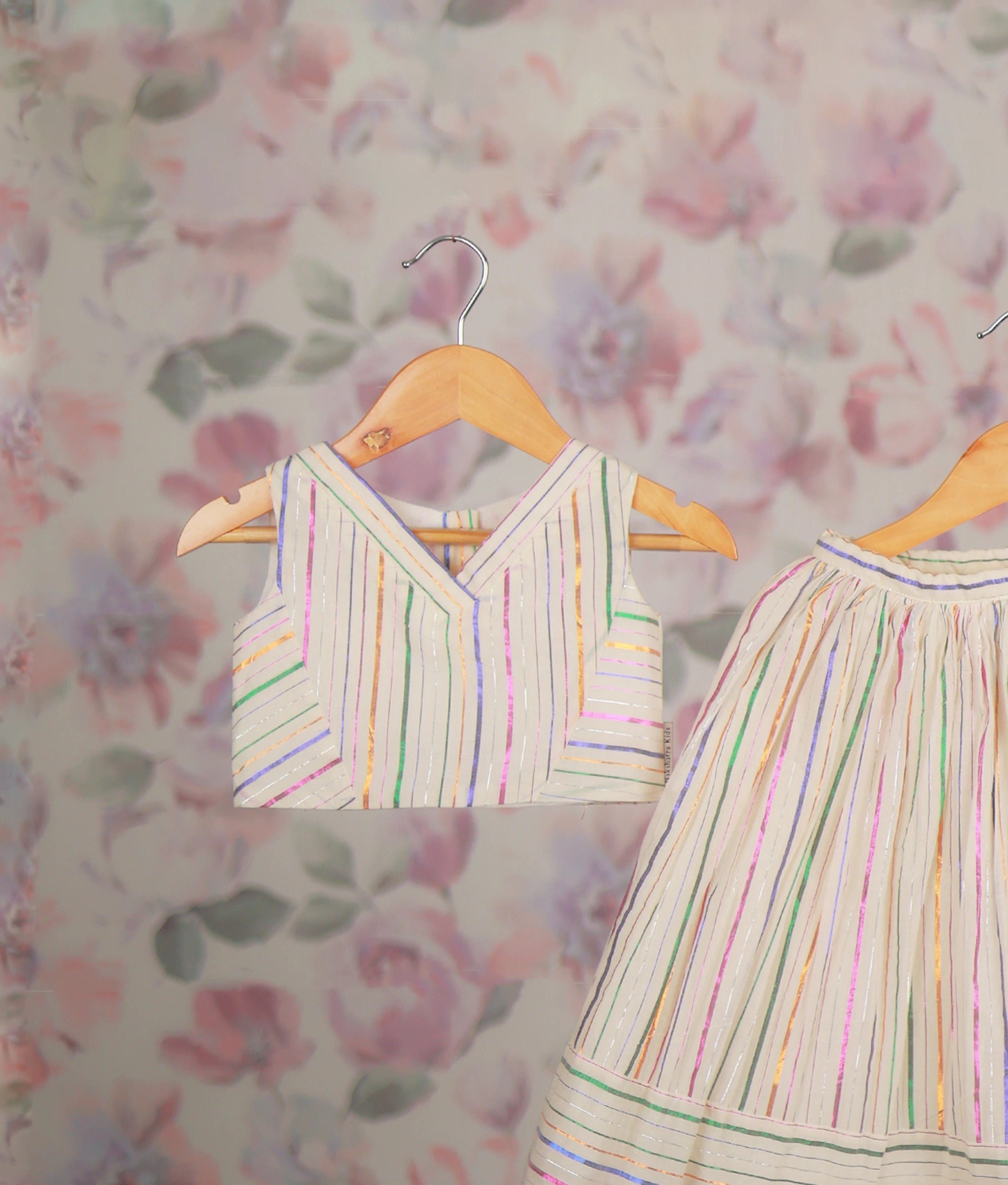 Close view of an ethnic dress with a multicolor striped short top and matching pleated skirt set.