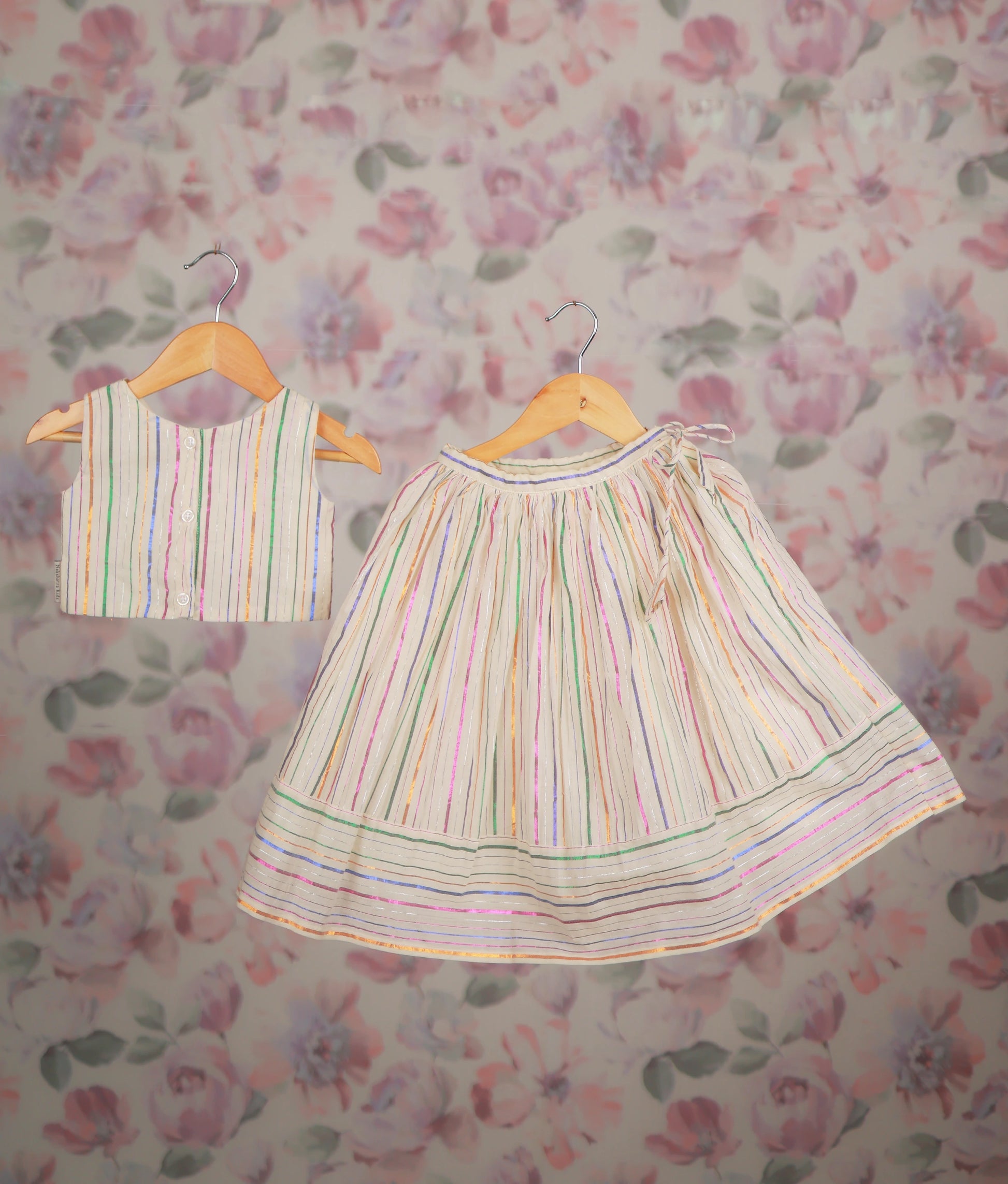 Back view of an ethnic dress with a multicolor striped short top and matching pleated skirt set.