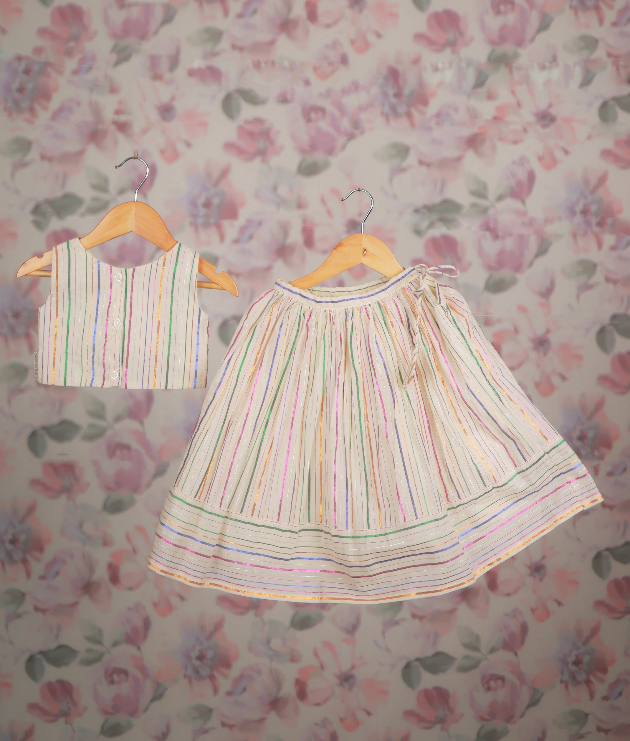 Back view of an ethnic dress with a multicolor striped short top and matching pleated skirt set.