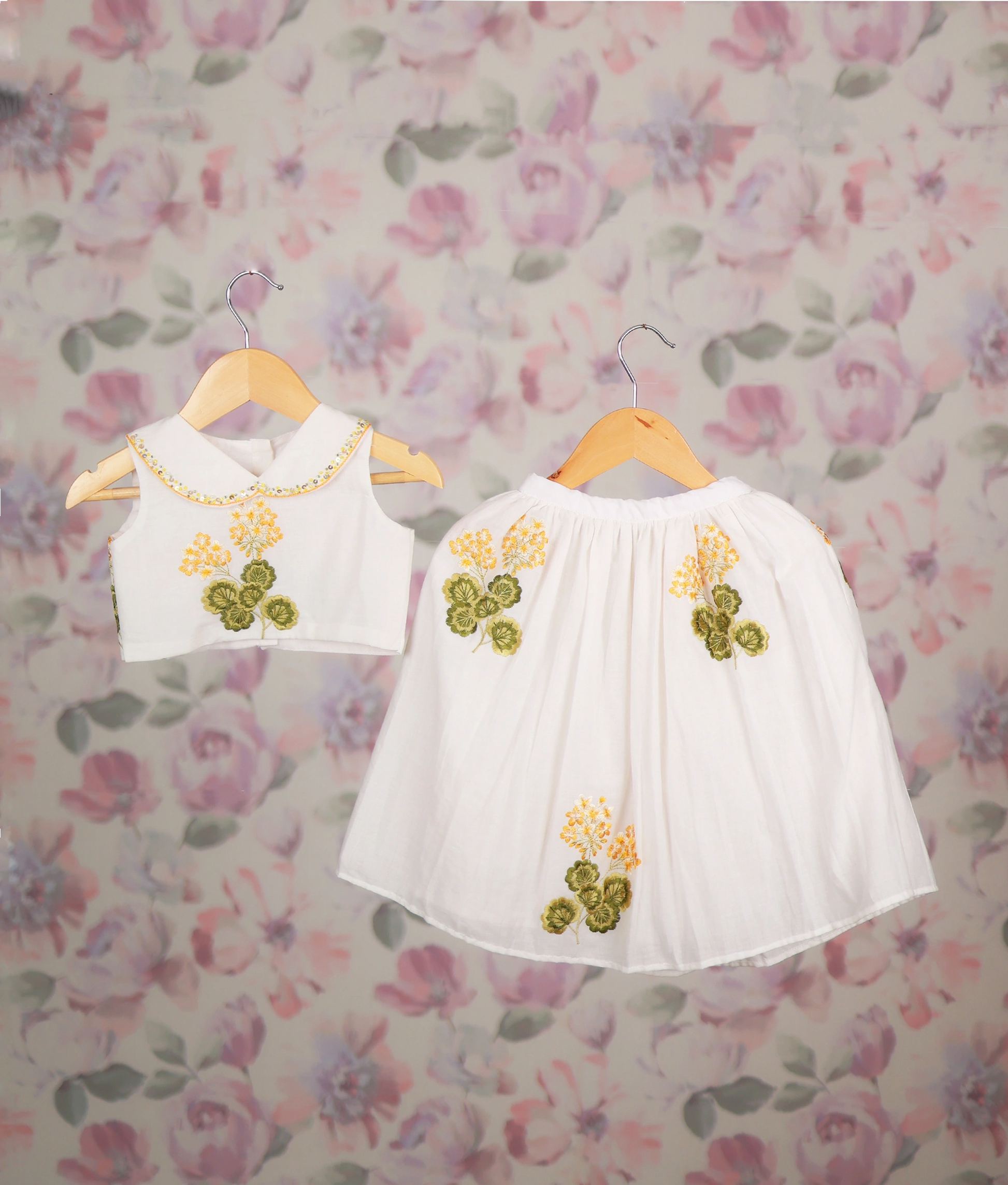 White baby girl skirt set with yellow floral embroidery and Peter Pan collar top, ethnic wear.