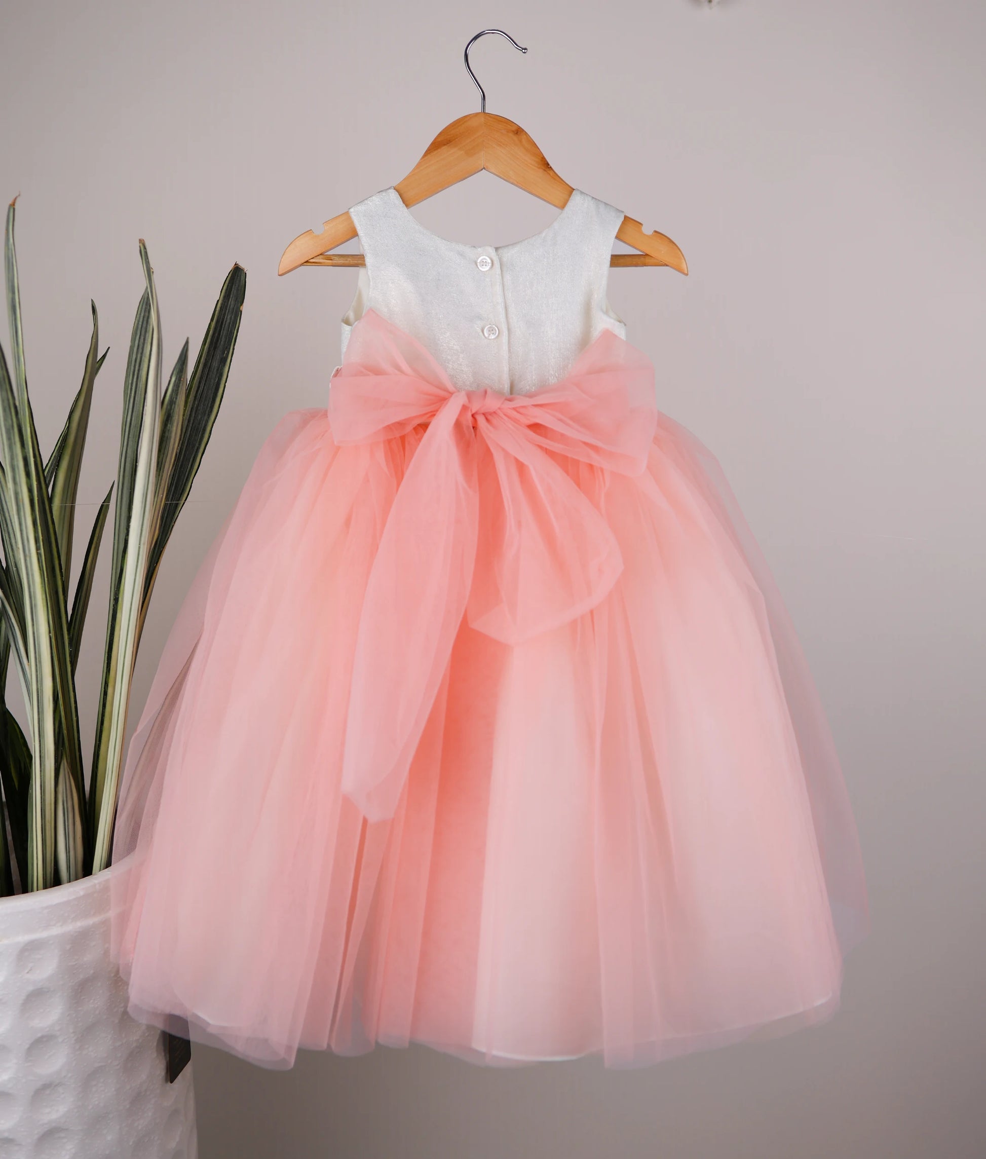 Back view of milan foil yoke with peach skirt birthday frock with white background 