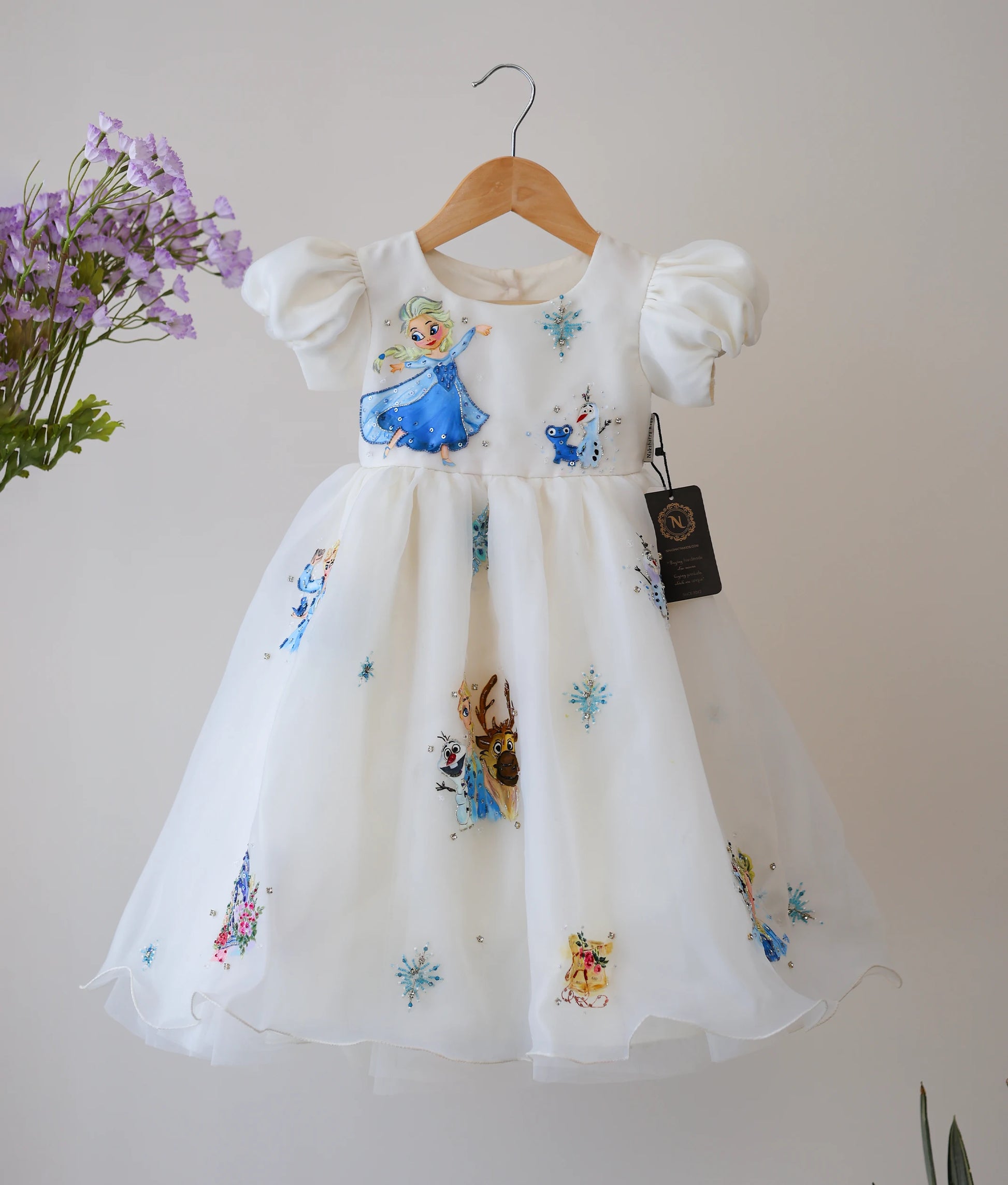 Front view of an off-white, plain organza disney princess themed birthday gown. 