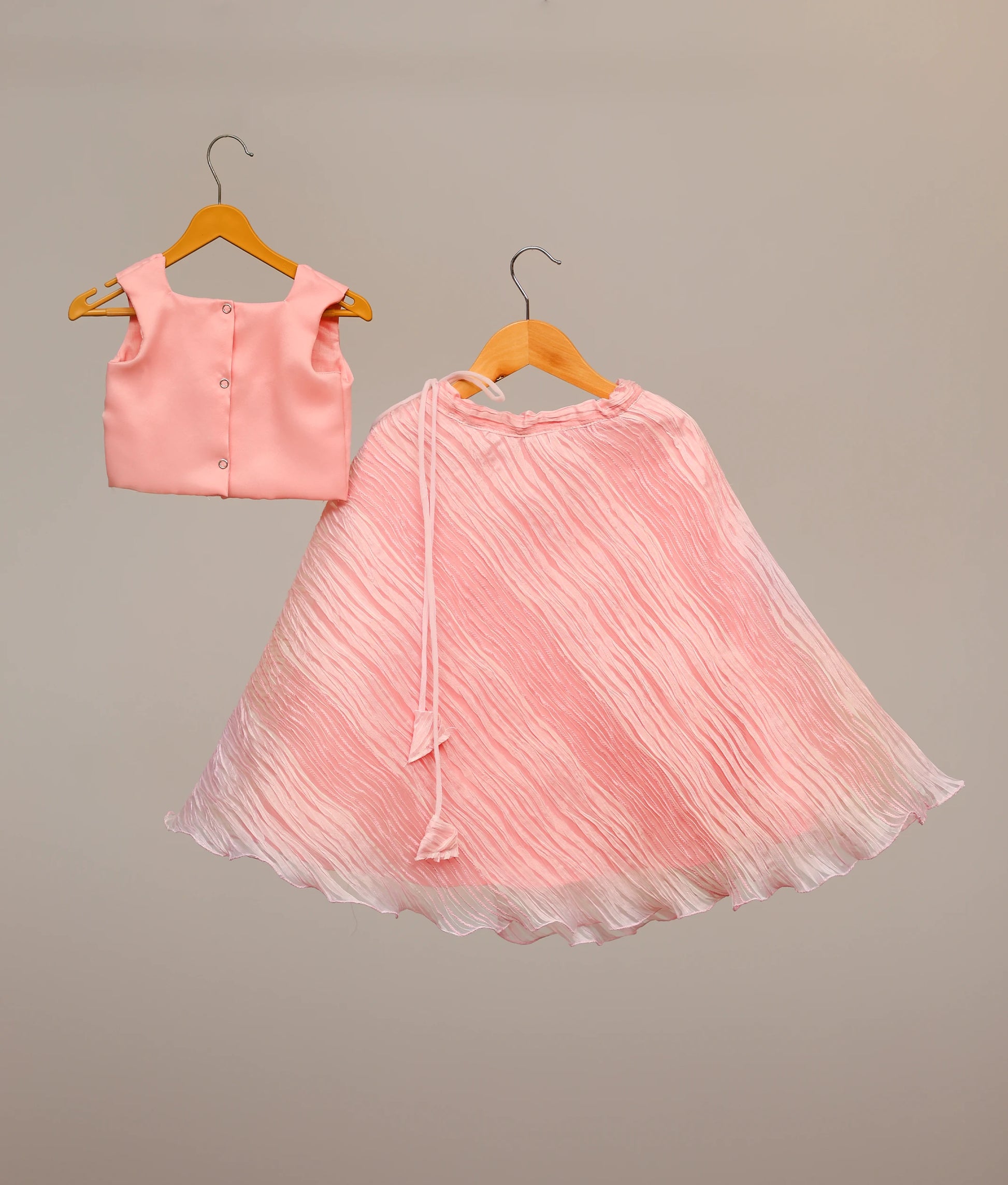 Back view of a kid's pink lehenga choli with a floral embroidered top and tuck organza skirt