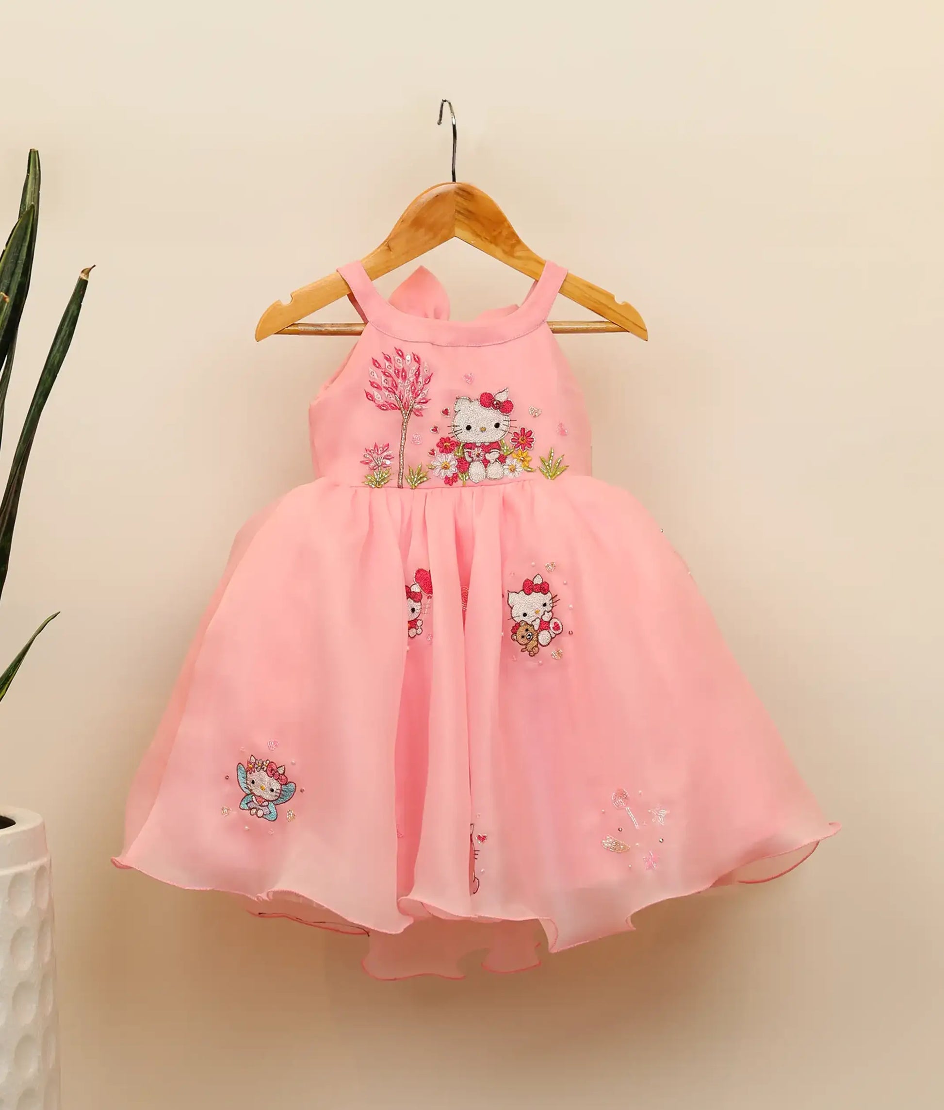 Front view of embroidery kitty-themed dress for baby girl against plain background