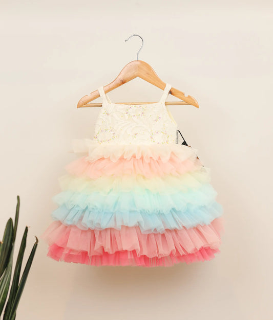 Front view of a multi-color tulle net handworked birthday frock against plain background