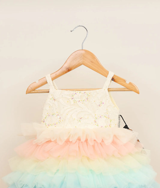 Close view of a multi-color tulle net handworked birthday frock against plain background
