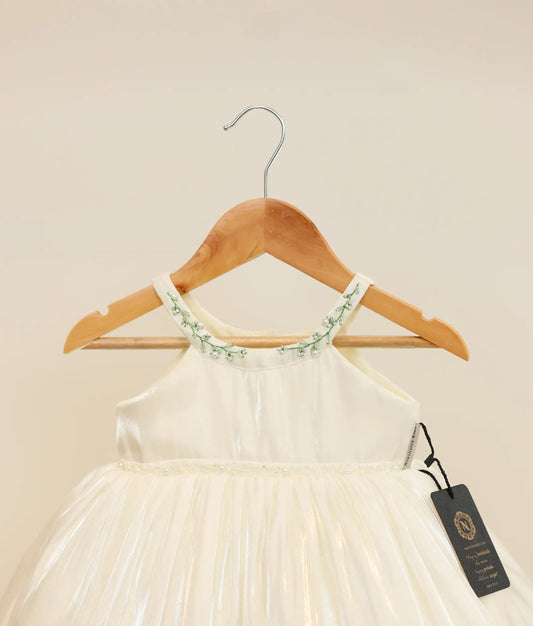 Close view of an off-white lacer organza handworked baptism frock against plain background 